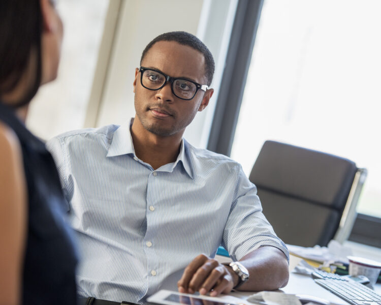 New York City,USA,A man and woman talking in an office. A man and woman talking in an office.